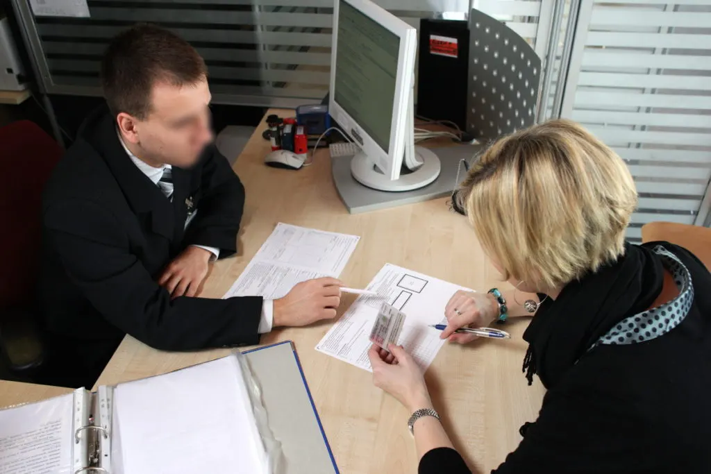 Сотрудник ужонда помагает заполнить заявление на замену водительских прав в Польше